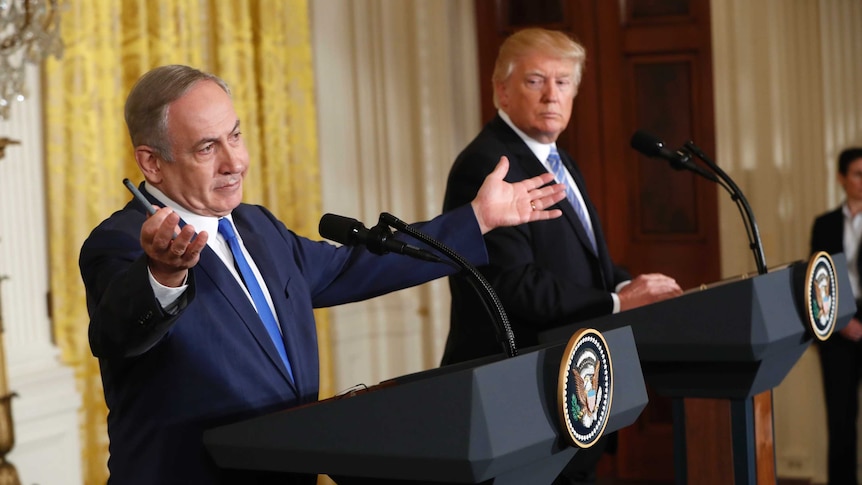 Israeli prime minister Benjamin Netanyahu gestures expansively as President Donald Trump looks on.
