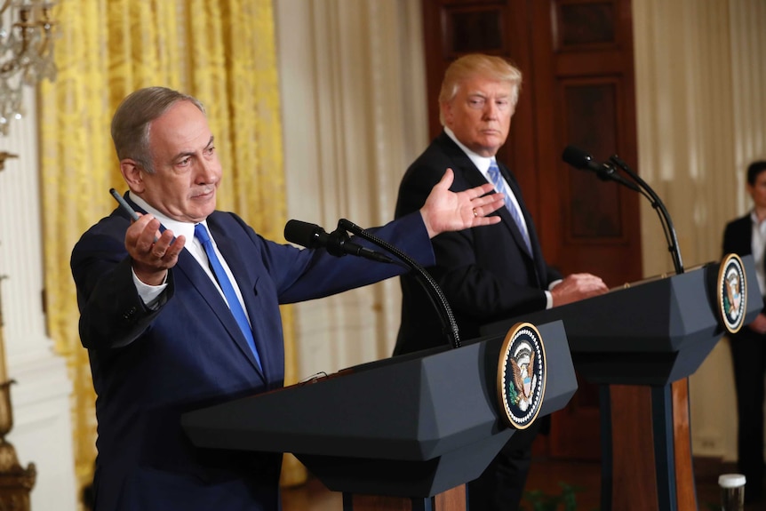 Israeli prime minister Benjamin Netanyahu gestures expansively as President Donald Trump looks on.