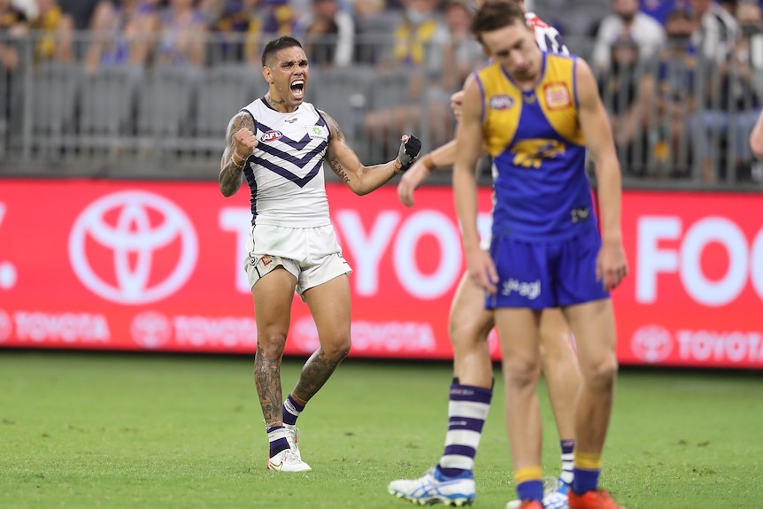 Michael Walters pumps both fists and yells as Brady Hough looks disappointed in the foreground