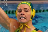 An Australian female water polo player holds the ball as she prepares to pass against Canada.