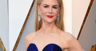 Nicole Kidman poses on the red carpet at the Oscars, wearing a royal blue strapless dress.