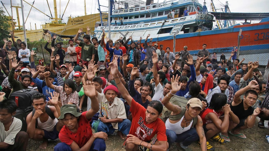 Burmese slave fishermen sitting in front trawlers vote to return home after being rescued in the Aru Islands, Indonesia