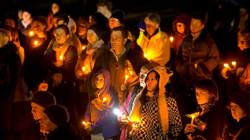 People hold candles during a vigil in Commonwealth Park