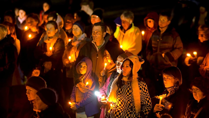 People hold candles during a vigil in Commonwealth Park, Canberra.