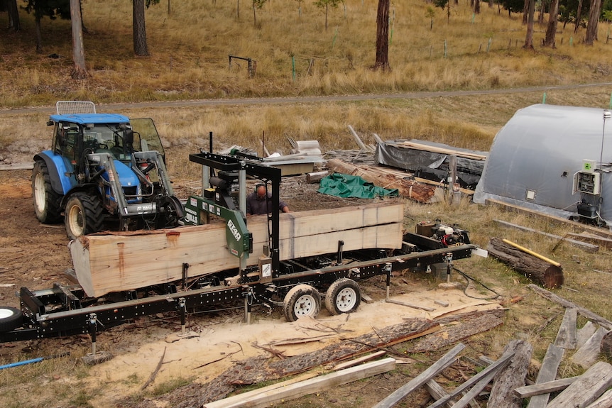 Photo of a man milling a tree.