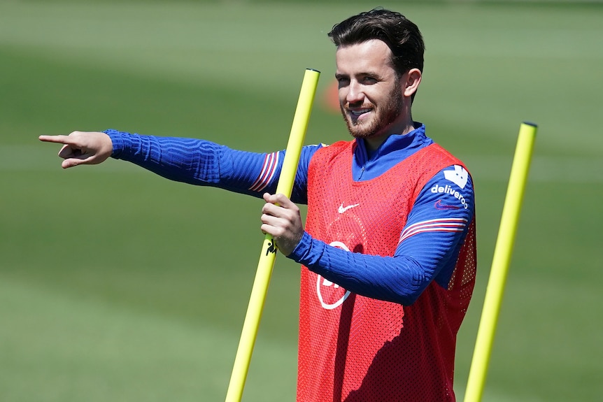 Ben Chilwell points while holding a yellow training pole