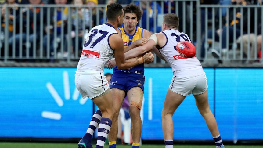 Andrew Gaff of the Eagles is tackled by Michael Johnson and Luke Ryan of the Dockers.
