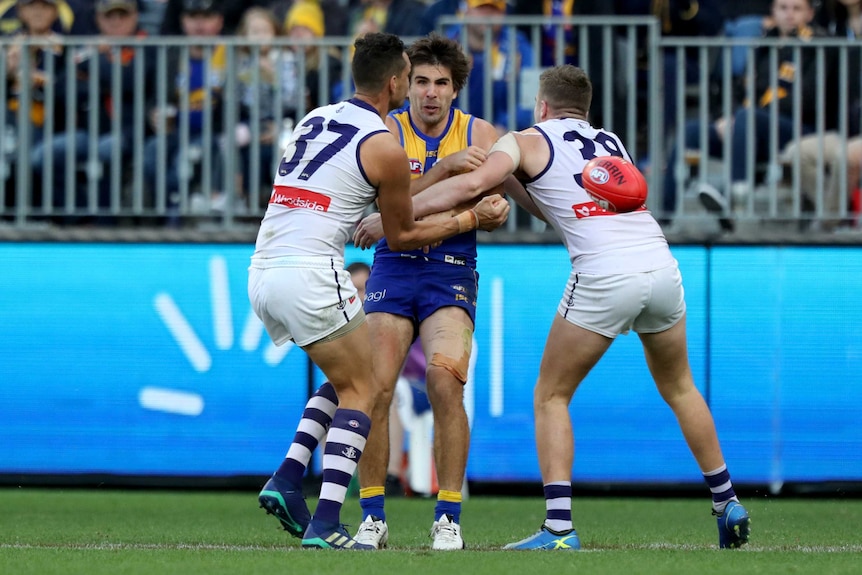 The Eagles' Andrew Gaff is tackled by Fremantle's Michael Johnson and Luke Ryan