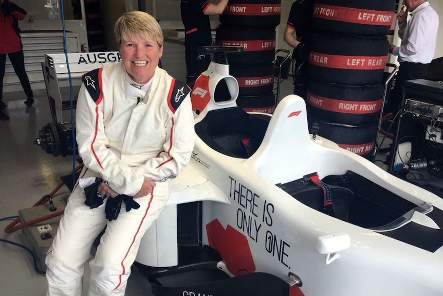Lynda Britten sitting on the side of the race car.