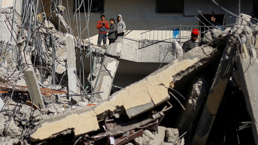 Children are pictured on the rubble on a building. 