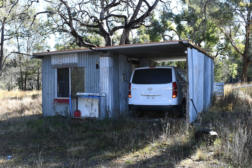 A white van parked near a fossicking shed