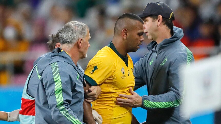 A Wallabies player looks down at the ground as he is taken from the field against Georgia at the Rugby World Cup.