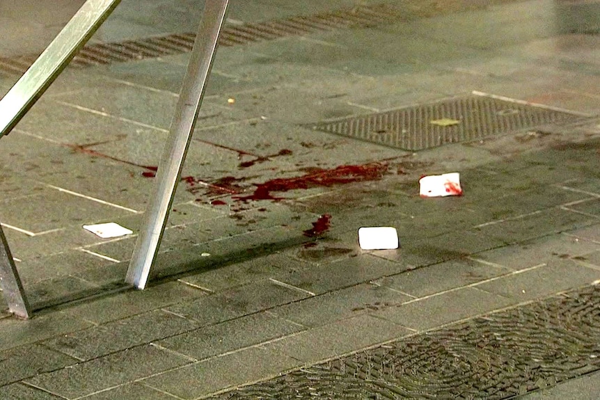 Blood on a pavement after a woman was stabbed.
