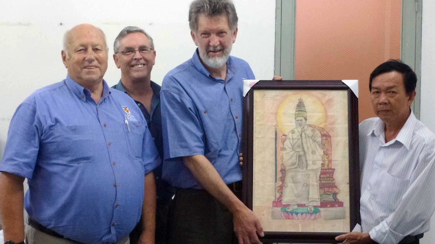 Derrill de Heer and Bob Hall return a picture to a Vietnamese museum.