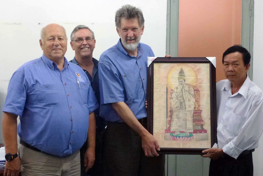 Derrill de Heer and Bob Hall return a picture to a Vietnamese museum.