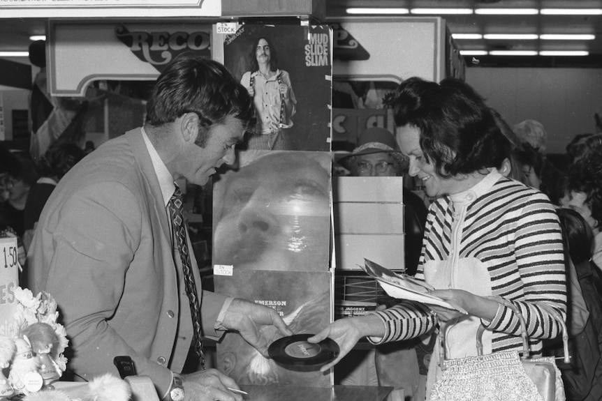 Neil Kerley signing copies of his record in an old photo.