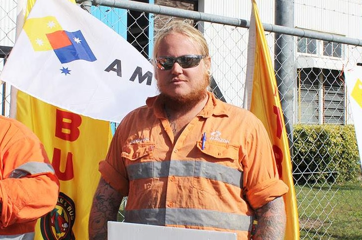 Shaun Jones, (with sign) outside the Aurizon Rollingstock Services facility in Rockhampton