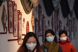 Women wearing face masks walk down the street in Beijing