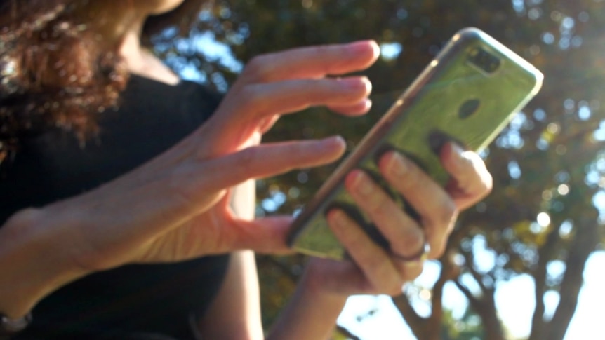 A woman's hands holding a mobile phone.