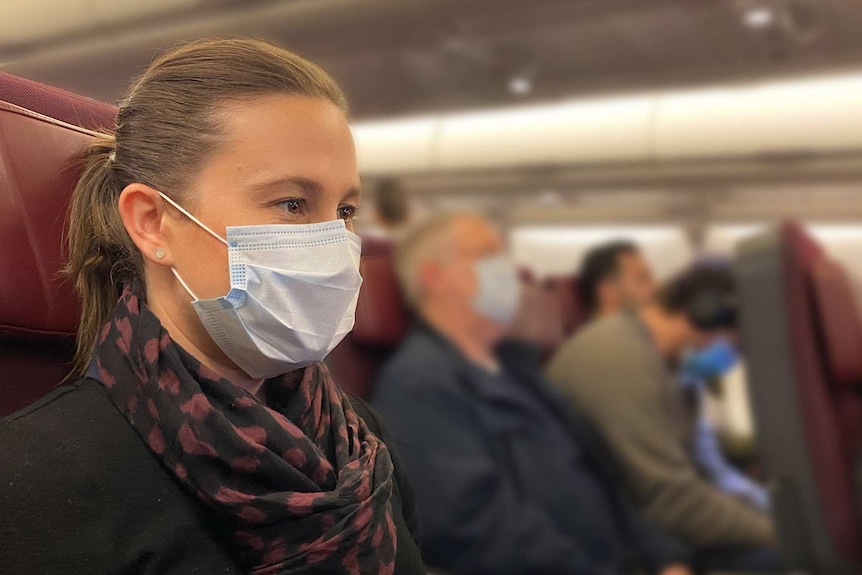 Photo of ABC News reporter Rachel Pupazzoni on a flight wearing a mask.