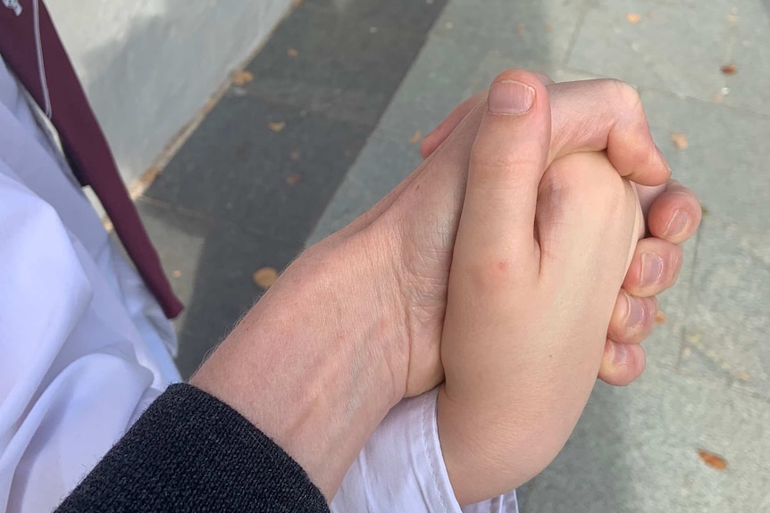 A child's hand inside his mother's
