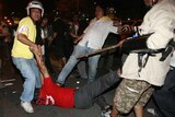 A government supporter is kicked by an anti-government demonstrator in Bangkok