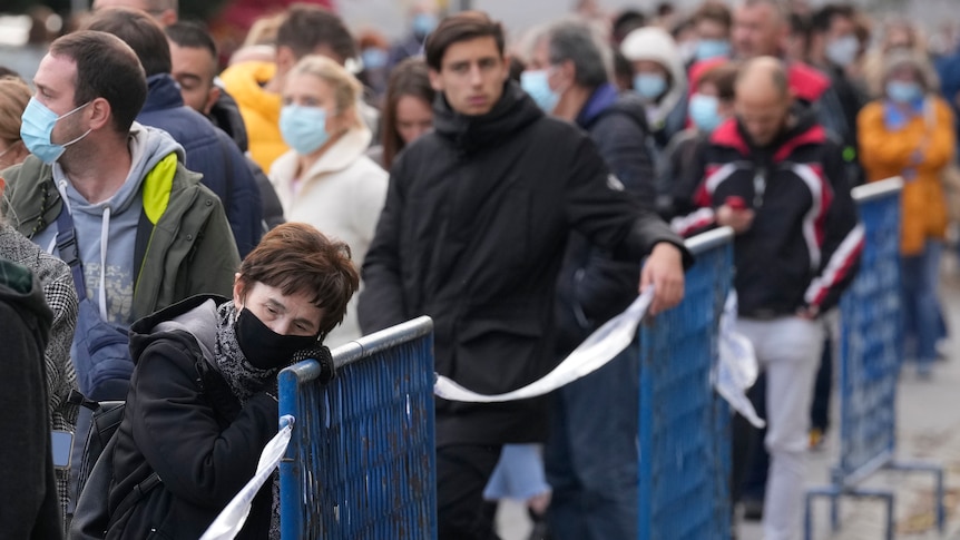 People in masks line up to be vaccinated