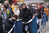 People in masks line up to be vaccinated