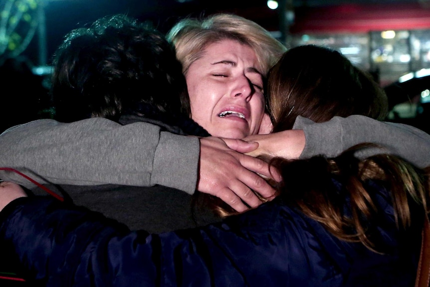 A ferry survivor embraces her children
