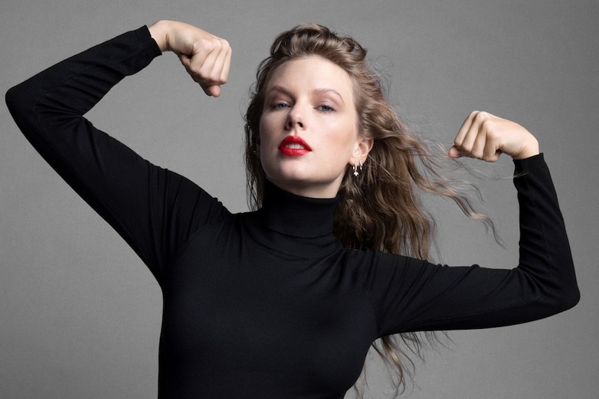 Taylor Swift, dressed in a black long-sleeved turtleneck and red lipstick, flexes her muscles in a photoshoot for Time.