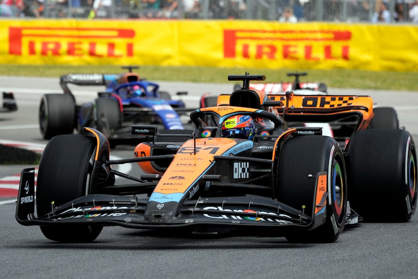 Oscar Piastri, in his orange Mercedes F1 car, turning right while racing, with several cars behind him.