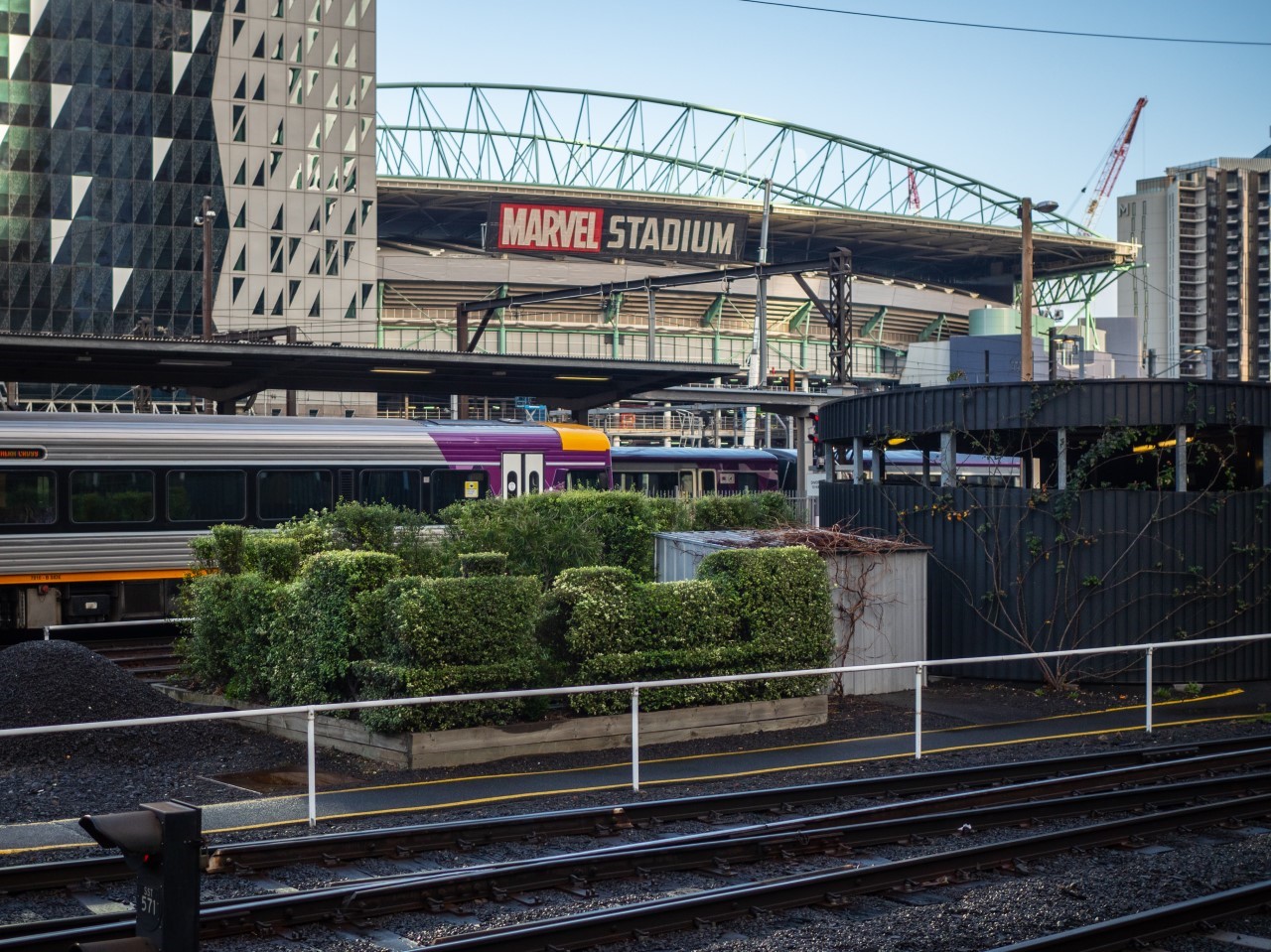 V-Line train driver behind locomotive-shaped hedges at Melbourne's Southern Cross Station - ABC News