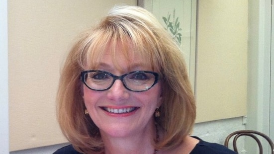 Celebrant Gaynor Cobby smiles while seated at the dinner table