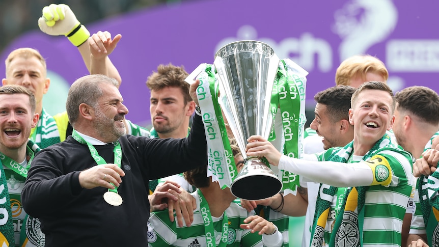 Ange Postecoglou and the Celtic players celebrating with the trophy.