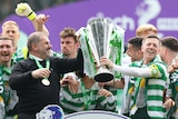Ange Postecoglou and the Celtic players celebrating with the trophy.