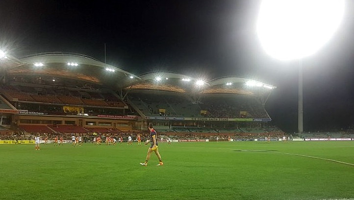 An Adelaide player on the field warming up during the women's AFL game