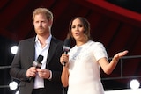 prince harry and meghan markle on stage at Global Citizen Live as Meghan speaks into a microphone