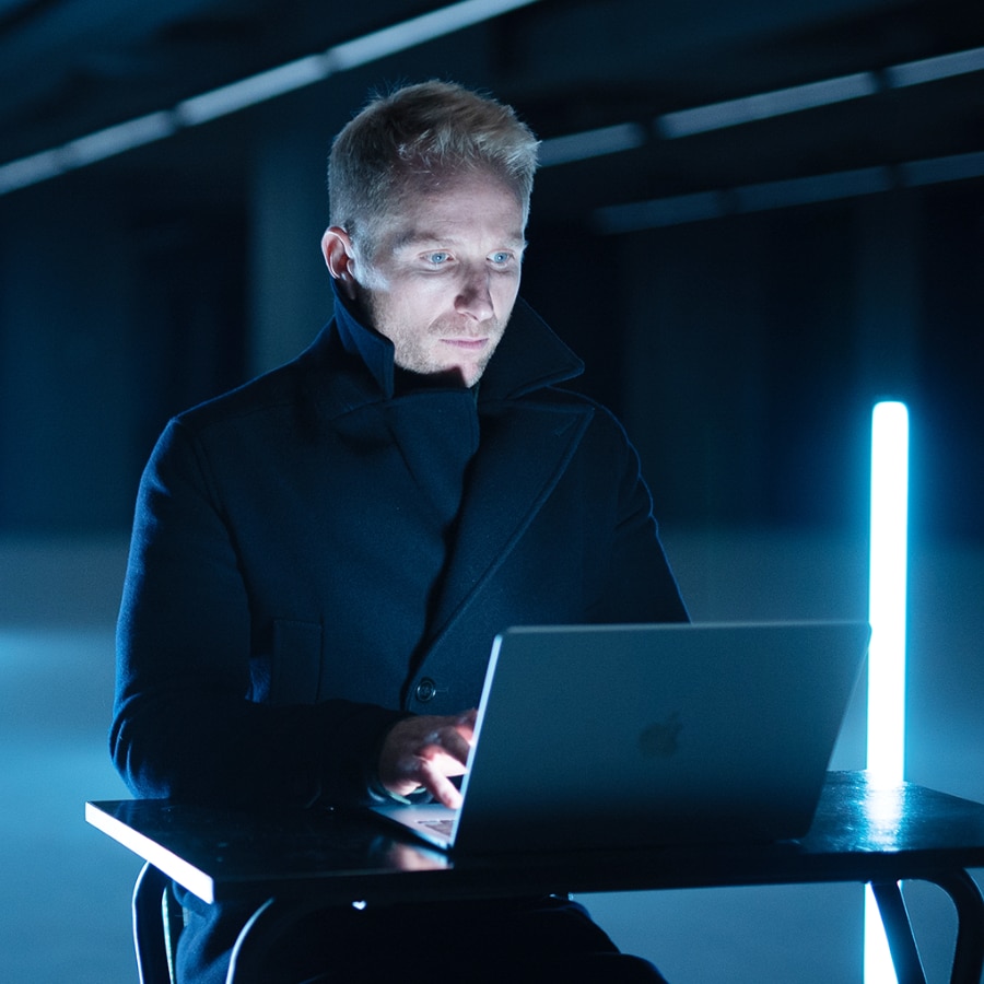 Show artwork for The Matter of Facts: Hamish Macdonald working on a laptop in a blue-lit room.