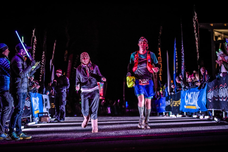 Chris Murphy at the finish line the Ultra Trail event in 2018, accompanied by his wife Nicole.