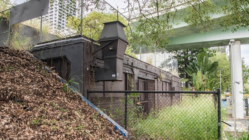 Small building built into rockface by Brisbane River