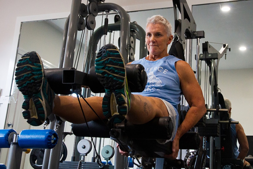Bev Francis does leg exercises on gym equipment.