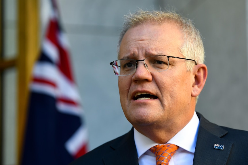 Le Premier ministre australien s'exprime lors d'une conférence de presse devant un drapeau australien