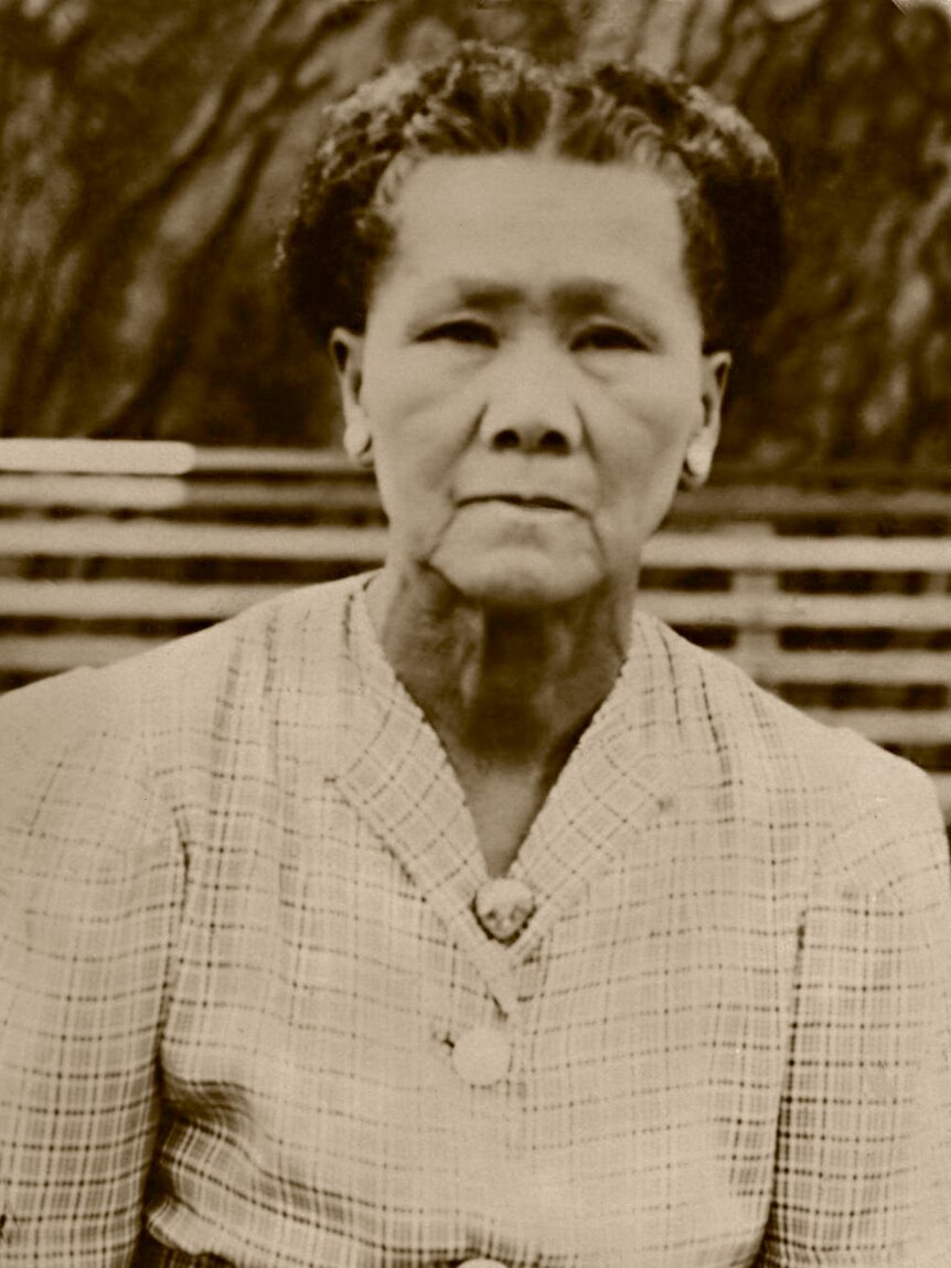A Chinese woman with hair braided in a typical 1940s checkered dress
