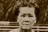 A Chinese woman with hair braided in a typical 1940s checkered dress