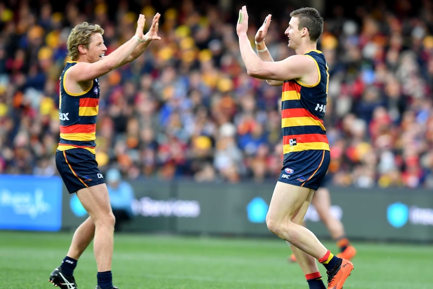 Rory Sloane and Josh Jenkins congratulate each other after an Adelaide Crows' goal.