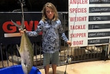 A boy holds a big fish.