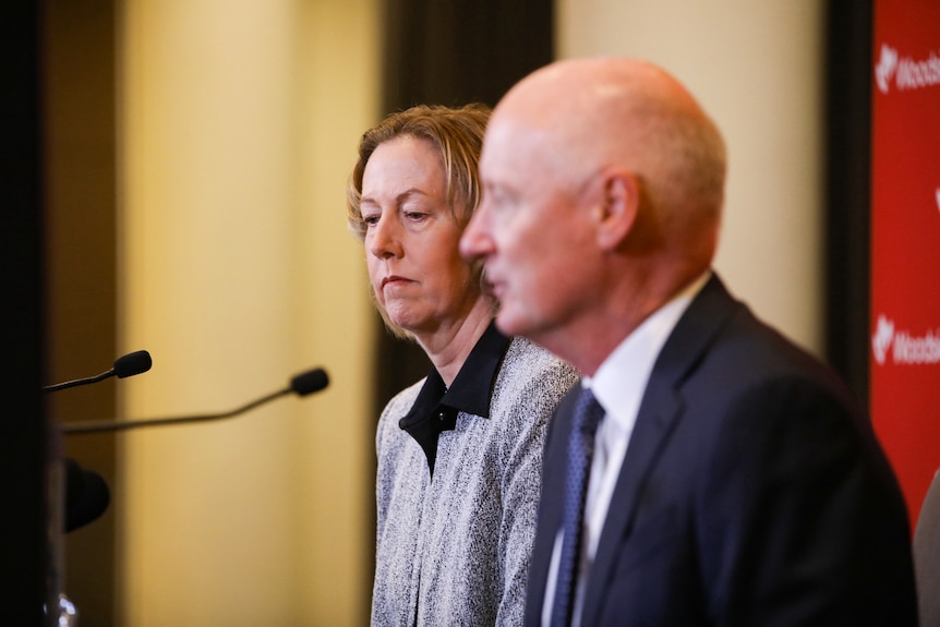 Woodside CEO Meg O'Neill and chair Richard Goyder sit at a press conference