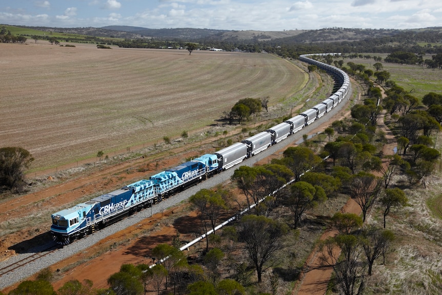 An aerial view of a long train on a track in rural Western Australia.