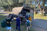 school students getting into an army vehicle 