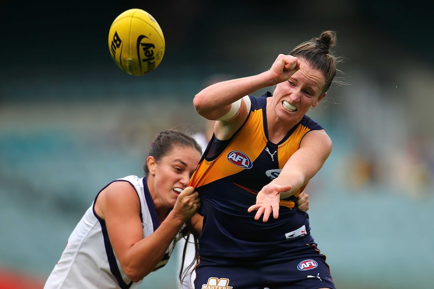 Kara Donnellan handballs while being tackled by Tarnica Golisano